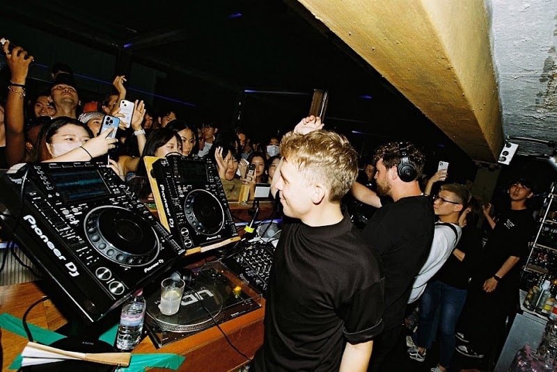 A live DJ set at PAPER, with the audience gathered close to the decks.